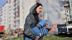 Una mujer con su hijo huye del bombardeo en Ucrania