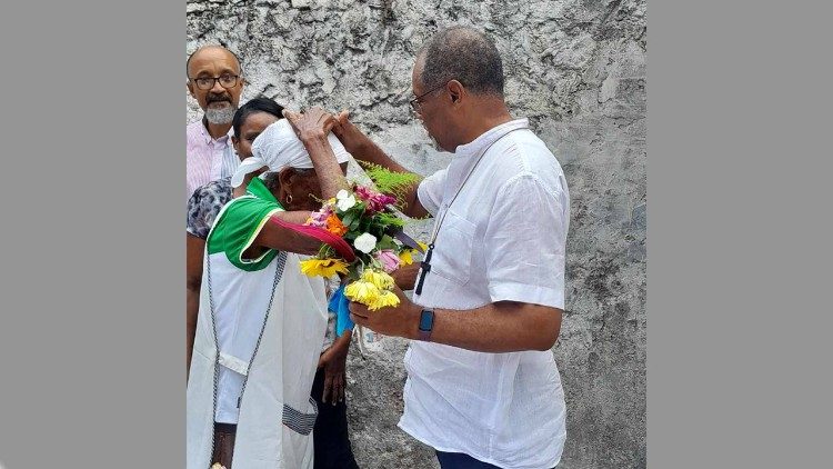 Dom Ildo recebe flores duma habitante da ilha e dá-lhe uma abenção. 