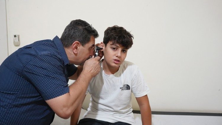 Dr. Elie Sakr examines a patient at a dispensary that operates within the camp. Photo: Raghida Skaff - CNEWA