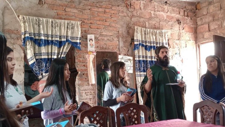 Algunos de los misioneros en una de las casas del Barrio implorando la bendición sobre la familia.