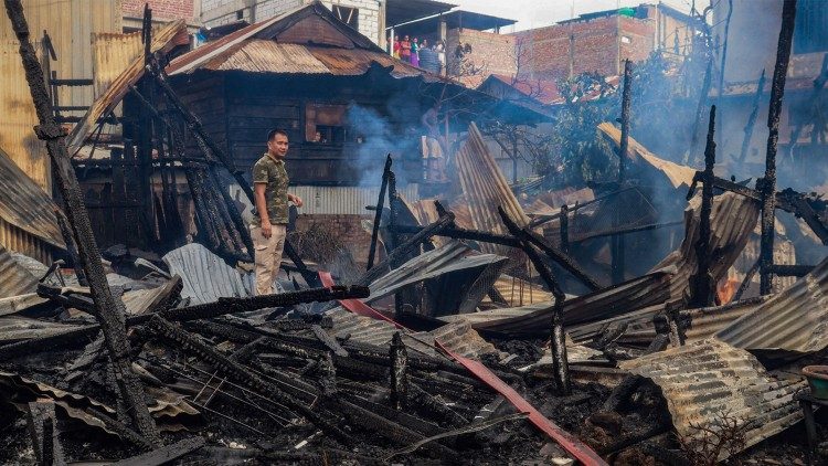 A man stands amid the charred remains of houses burned down in a suspected arson attack, following ongoing ethnic violence in Imphal on August 27, 2023. (Photo by AFP)