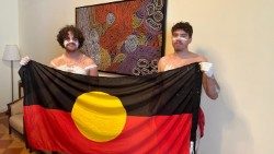 Zane Ratcliff and Ryan St. John hold an Australian Aboriginal flag