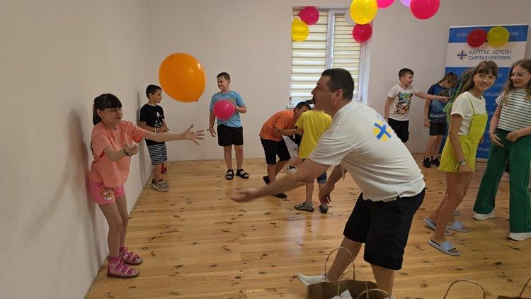 Algunos niños juegan asistidos por parroquianos en Ucrania