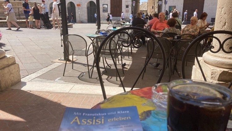 Der spirituelle Assisi-Führer im Einsatz auf einem Tisch in einer Bar in Assisi - Foto: Michael Hermann 