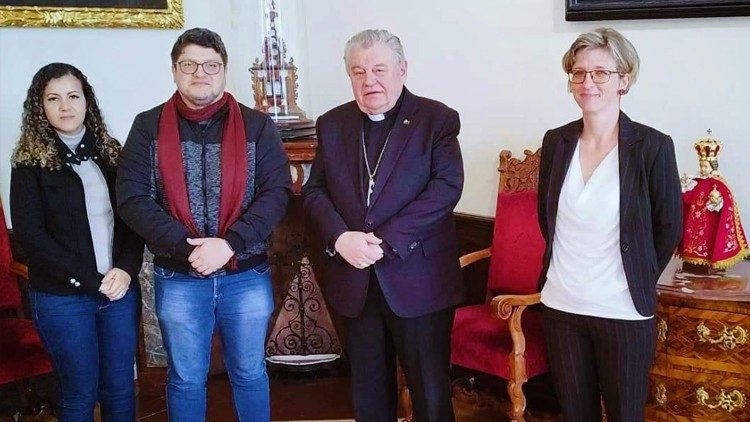 Cícero Moraes acompanhado pela esposa, ao lado do cardeal Dominik Jaroslav Duka e  tradutora. Foto tirada no Palácio do Arcebispo de Praga, ao fundo o Menino Jesus de Praga.