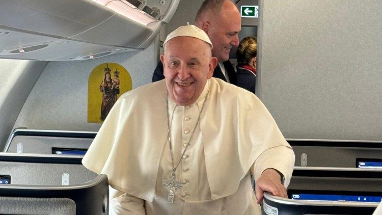 Pope Francis smiles as he boards the papal plane