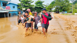 Members of a displaced Burmese family walk on a muddy path in the aftermath of Typhoon Yagi. Photo: Fr. Girish Santiago