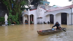 A man is seen paddling through floodwaters outside a church in Chau Thuy Parish, Vietnam. Photo by the Archdiocese of Hanoi