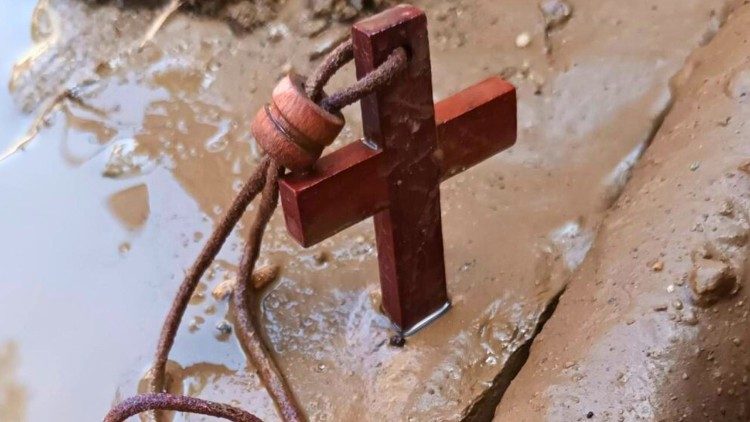 A wooden cross is among debris buried in the mud left behind by historic flooding in northern Thailand. (Photo by Joseph Yothin Kano / Diocese of Chiang Rai)