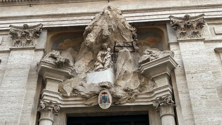 Fachada da igreja de Santa Maria di Monserrato, alto relevo com rochas, a Virgem e o Menino serrando a montanha, tema iconográfico da igreja