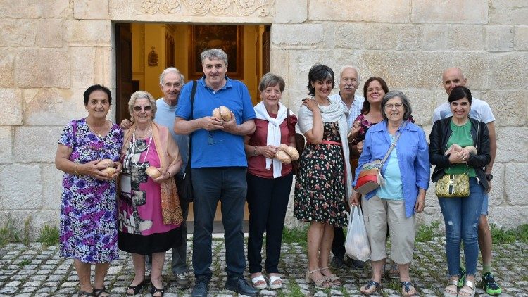 Giustino Parisse insieme ai suoi compaesani di Onna dopo la distribuzione del pane benedetto in occasione della festa di san Pietro, giugno 2023